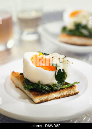 Soft-boiled egg,spinach and grated gruyère on toast Stock Photo