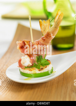 Gambas wrapped in bacon on toasted bread Stock Photo
