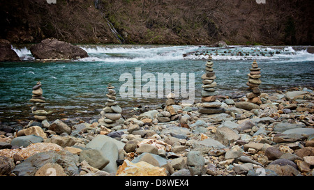 Pebble Cairn Balancing Towers by gushing river at Dakigaeri Senboku Akita Japan Stock Photo