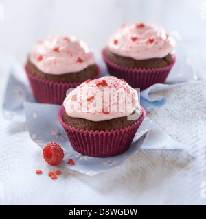 Chocolate cupcakes topped with raspberry whipped cream Stock Photo