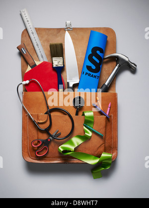 Leather bag full of different objects, studio shot Stock Photo