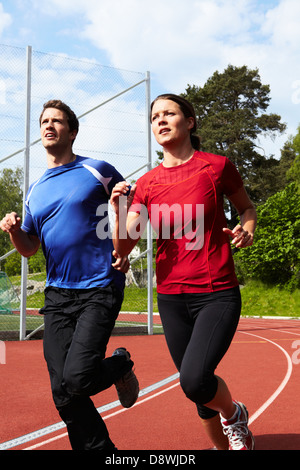 Woman and man jogging on running track Stock Photo