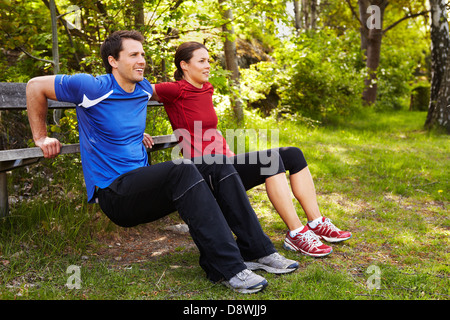 Woman and man exercising in park Stock Photo
