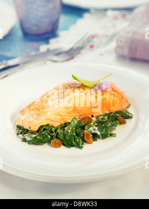 Salmon with spinach,raisins and creamy sauce Stock Photo