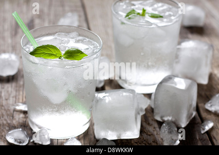 Glass of water with ice cubes on vintage wooden boards Stock Photo