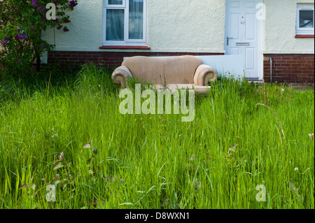 Abandoned sofa in overgrown garden Stock Photo
