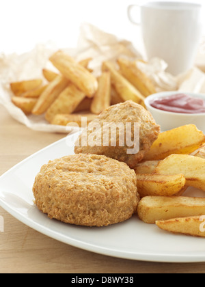 beer battered green fish cakes chips tomato sauce cup of tea plate table Stock Photo