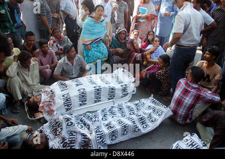 Families of the four people, who were abducted, shot and then dumped in Malir area, along with dead bodies are protesting against their relatives killing during demonstration outside CM House in Karachi on Wednesday, June 05, 2013. Four individuals three have been identified as Farhan, Mehtab, Tauseef while one remains unidentified. The four men  were abducted, as they made their way to work early in the morning. Three of the individuals were killed while one was dumped while still alive but seriously injured. Stock Photo