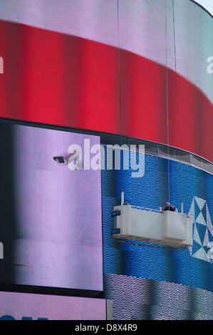 London, UK. 5th June, 2013. Workmen on a gantry maintain the iconic electronic advertising screens in the West End at Piccadilly Circus Credit:  Malcolm Park/Alamy Live News Stock Photo