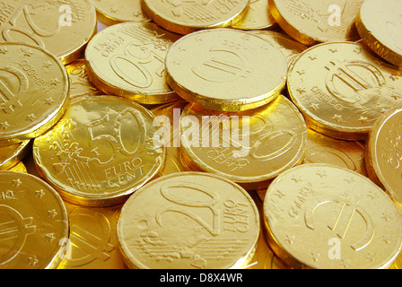 Pile of chocolate coins wrapped in shiny golden tinfoil Stock Photo