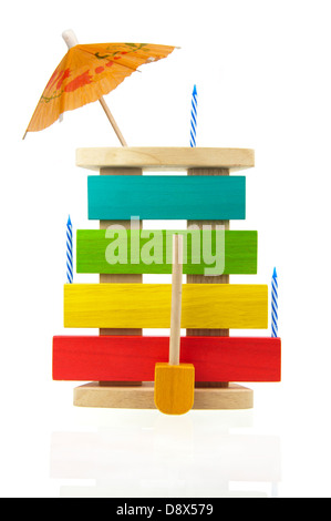 Wooden and colorful kid xylophone decorated with candles and Chinese party umbrella and isolated on white background Stock Photo