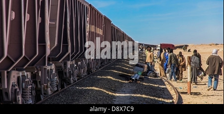 People wait to board the iron ore train in Nouadhibou, Mauritania Stock Photo