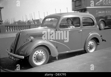 Historical picture from1950s of a lady sitting in the passenger seat of a car of the era parked beside the pavement on Tower bridge in London England, UK. Stock Photo