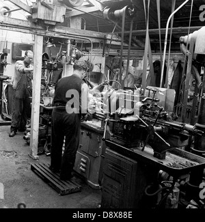 1950s, historical, male workers at machines repairing or retreading ...