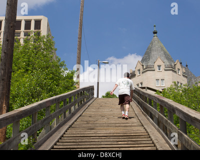 man climbing up wooden stairs for exercise Stock Photo