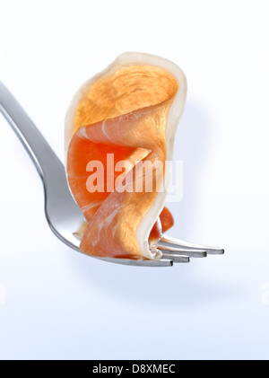 Slice of raw ham on a fork Stock Photo