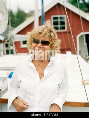 Woman leaning against ship in a harbour. Stock Photo