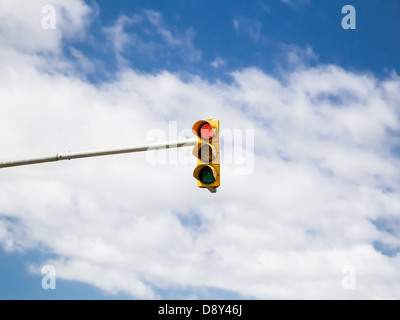 Red traffic light on cloud sky background. Photo. Stock Photo
