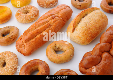 A large group of breads and bagels viewed for overhead on white with reflection. Stock Photo