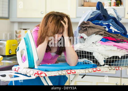 A woman stressed out doing the ironing Stock Photo