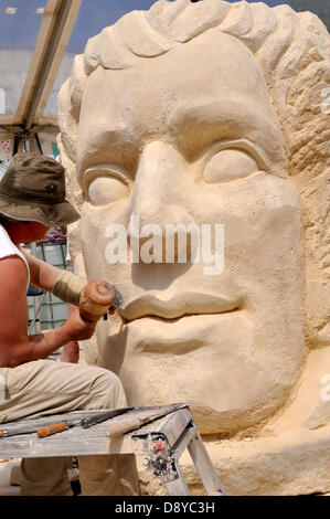 Bristol Festival of Stone 2013, 6th June, UK. British artist, Ben Dearnley carving a face 'The Father of the Bicycle' into a 5 ton block of stone at the festival which extends to the 9th of June in central Bristol harbourside and includes artists demonstrating the craft from a number of countries. Stock Photo