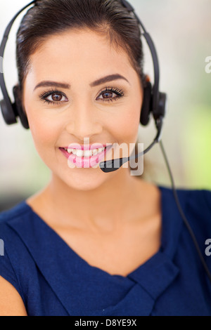 Closeup portrait of a happy young call center employee smiling with a headset Stock Photo