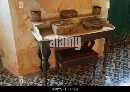 Colonial antique table covered with baskets in the main building at Hacienda Yaxcopoil, Yucatan, Mexico Stock Photo