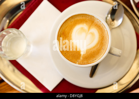Coffee espresso with coffee art decorated heart in froth Stock Photo