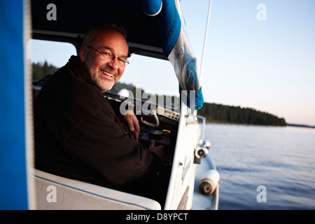 Man driving boat, smiling Stock Photo