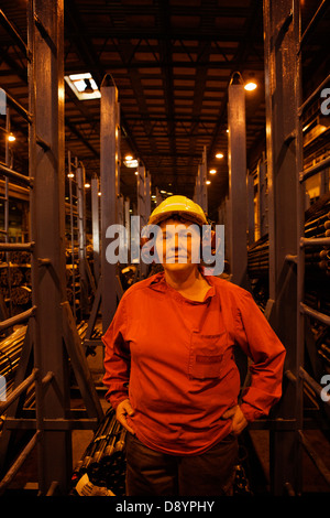 Woman wearing protective workwear standing in factory Stock Photo