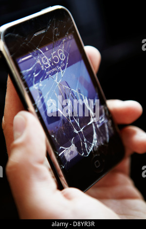 Person holding mobile phone with broken screen Stock Photo