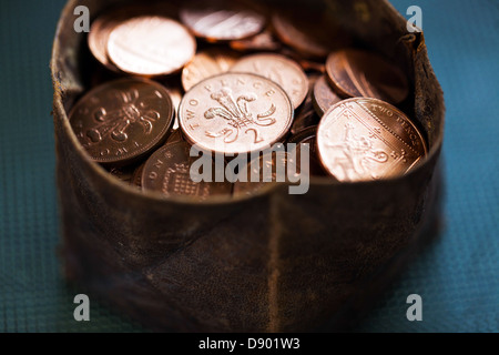 Small leather pouch full of two pence coins, London, England, UK Stock Photo