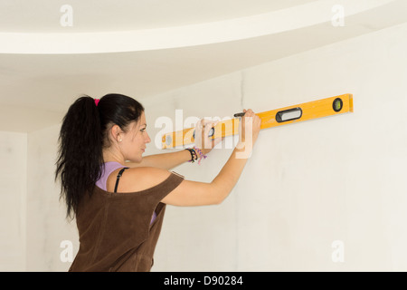 DIY woman using spirit level to work out measurements. Stock Photo