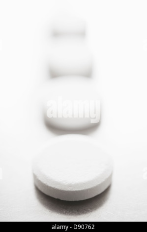 Pills in row on white background Stock Photo