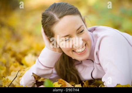 A smiling woman laying on the ground. Stock Photo