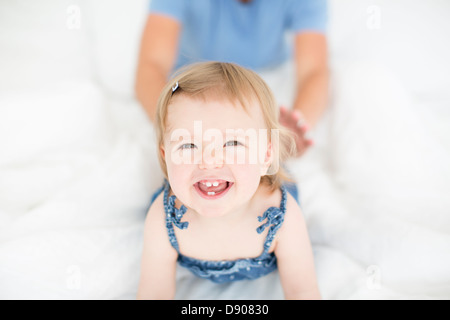 Studio shot of happy little girl with father in background Stock Photo