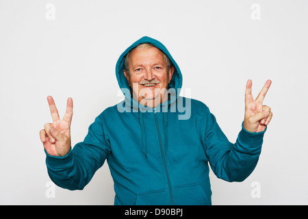 An old man doing the v-sign. Stock Photo