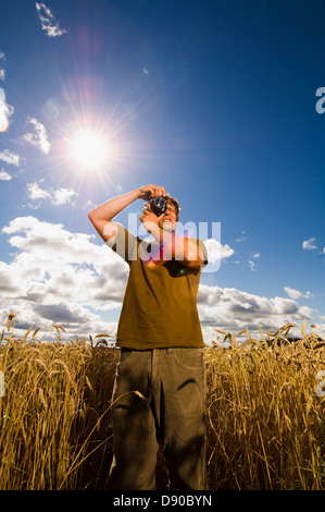 Man taking photographs in a field, Sweden. Stock Photo