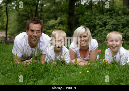 Family lying on grass, Sweden. Stock Photo