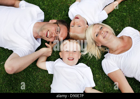 Family lying on grass, Sweden. Stock Photo