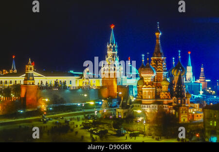 May 1, 1987 - Moscow, RU - Colorfully iIlluminated at night in honor of May Day, this panoramic view shows the most famous tourist attraction in Moscow, Saint Basil's Cathedral, in right foreground. Behind it, rising from the Kremlin Wall in center is the the Savior Clock Tower (Spasskaya Tower), an illuminated red star at its apex. At far left is the Alarm Tower (Nabatnaya Tower). Other Kremlin domes, spires and towers can be seen in background behind the walls. (Credit Image: © Arnold Drapkin/ZUMAPRESS.com) Stock Photo