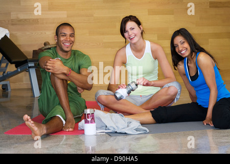 Smiling persons stretching in a gym. Stock Photo
