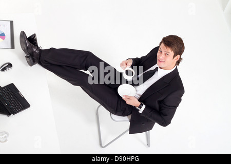overhead view of young businessman drinking coffee in office Stock Photo