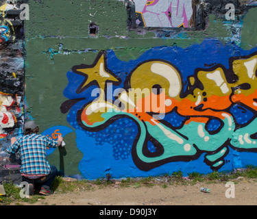 Graffiti artist at work on a wall in Brighton Stock Photo