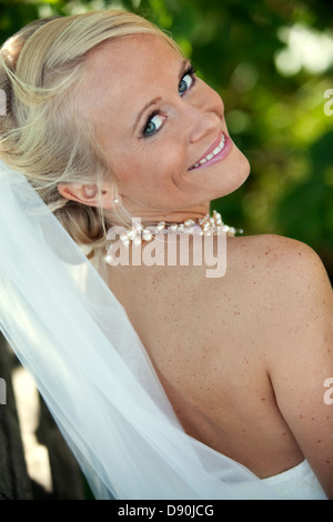 Smiling bride looking over shoulder Stock Photo