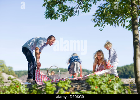 Family laying down blanket for picnic Stock Photo