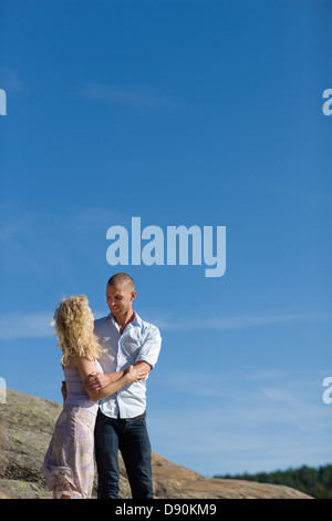 Couple standing on rock and looking at each other Stock Photo
