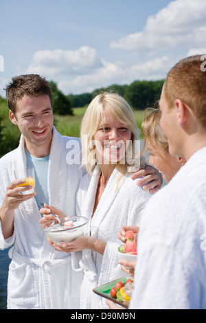Couples in bathrobe having breakfast, smiling Stock Photo