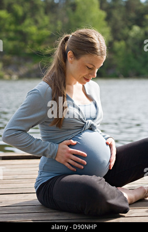 Pregnant woman on jetty Stock Photo