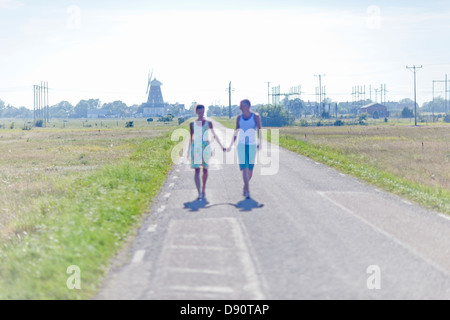 Couple walking down country road Stock Photo